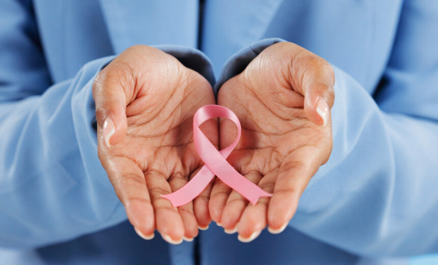 Hands, pink ribbon and breast cancer support with awareness and healthcare icon on blue background